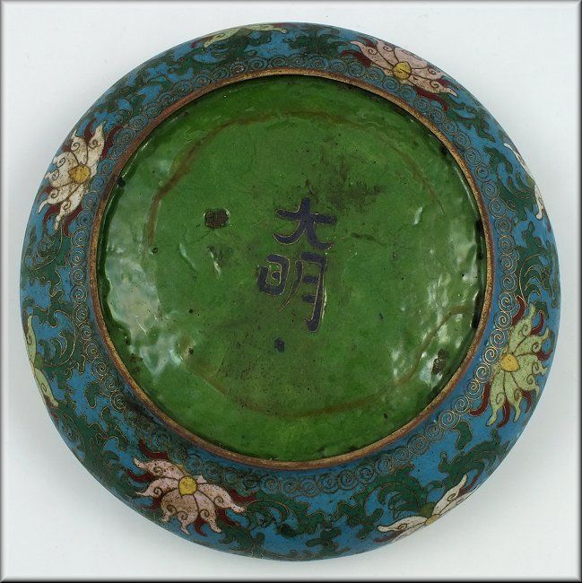   cloisonne floral designs along with a green interior and bottom it is